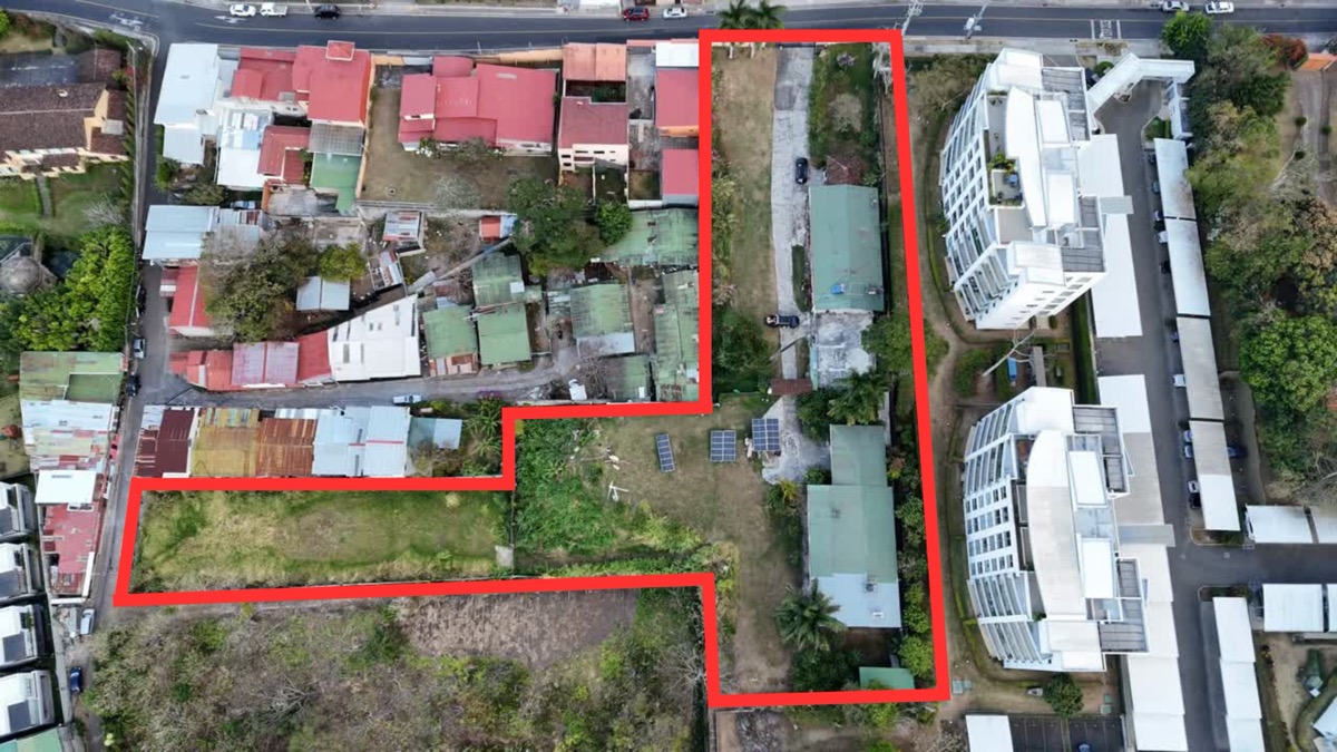 Aerial view of the Escazu property outlined in red beside nearby condominium buildings.